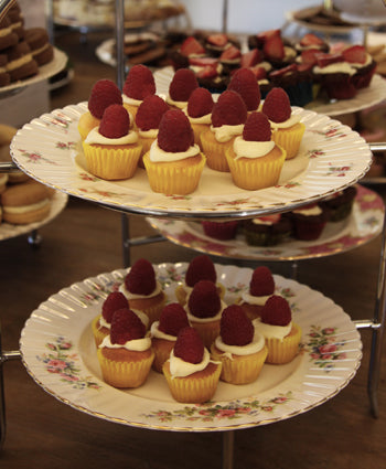 Handmade chocolate cups with red berry tops on a serving stand, artisan style and festive.
